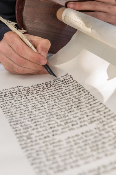 אדם כותב ספר תורה כשהוא מגולגל